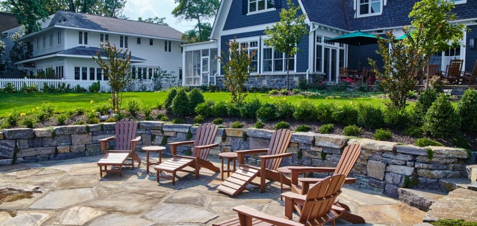 Suburban,backyard,patio,with,adirondack,chairs,and,lush,garden